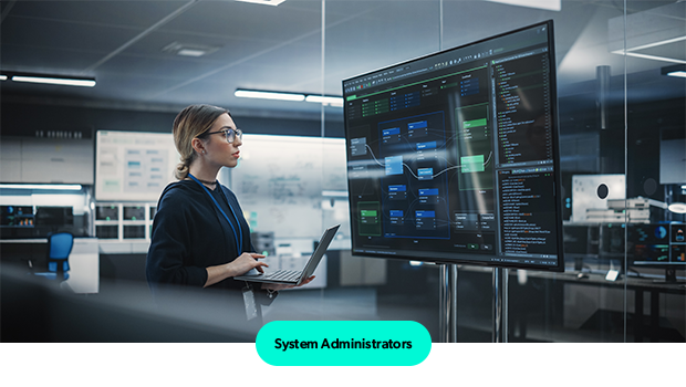 Person standing infrom of big screen with laptop.
