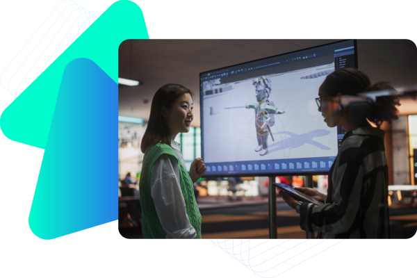 Two students stand in front of a large monitor displaying 3D modeling software in a classroom.