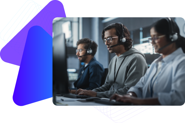 Three people wearing headphones working at computers in a dark room.