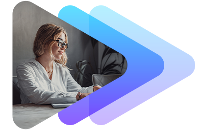 A woman wearing glasses working on a laptop at a desk.