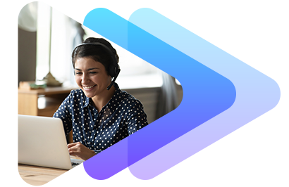 A smiling woman with curly hair working on a laptop indoors.