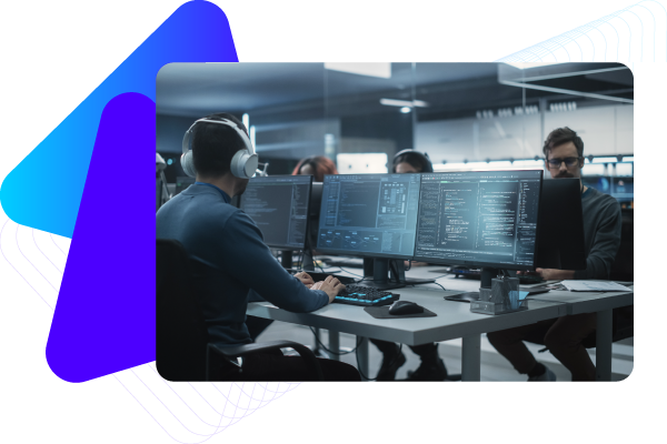 Two people working at computers with multiple monitors in a modern office setting.