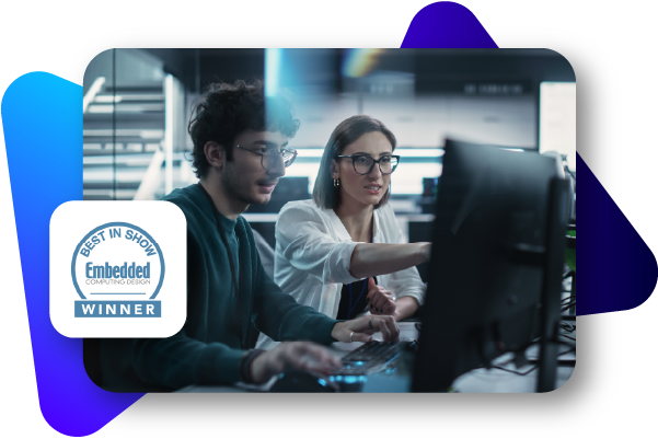 Two people work together at a computer in a modern office setting.