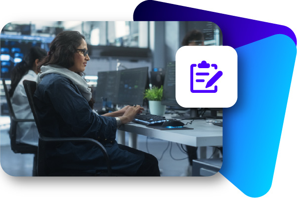 Woman with glasses working on a laptop at a desk with a potted plant and water bottle.