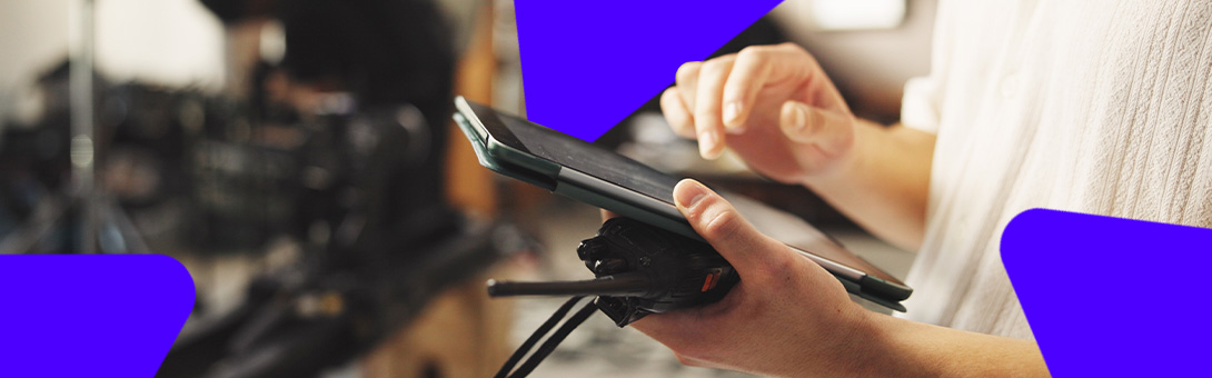 A person holding a smartphone with a camera, focused on the screen, with blurred background.